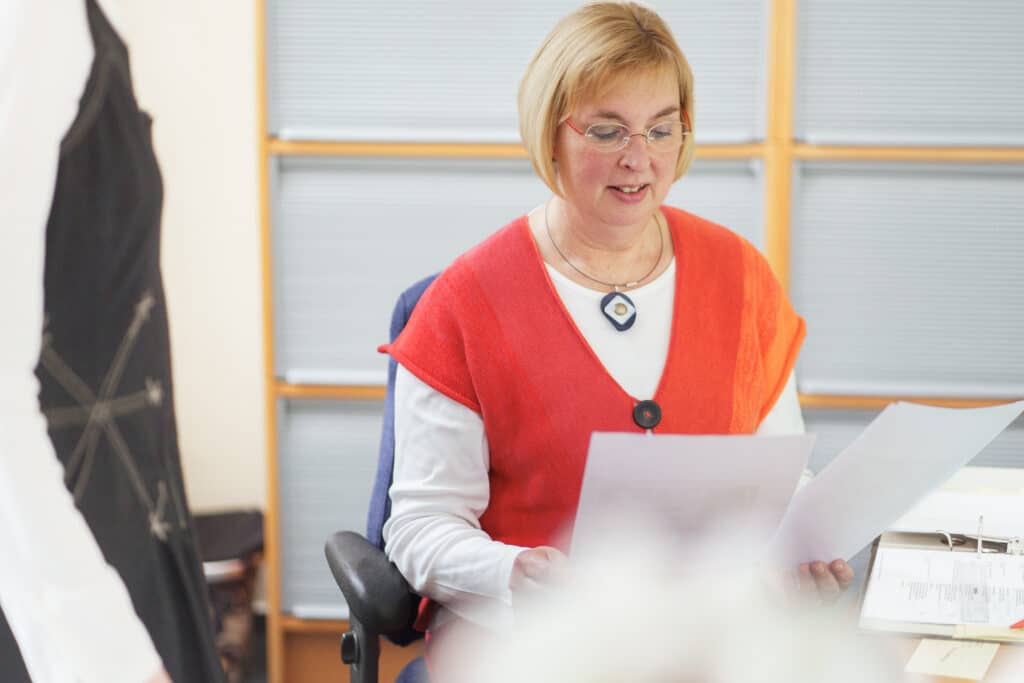 Frau hält Papiere in der Hand